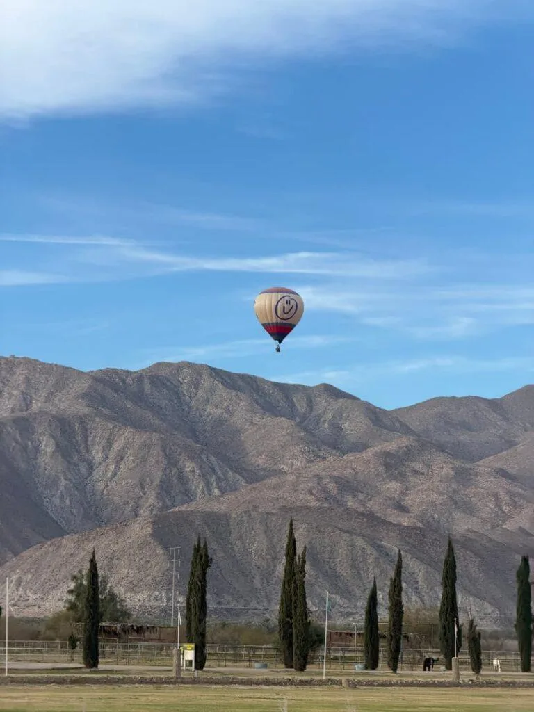 Hot air balloon glowing against the early morning sky